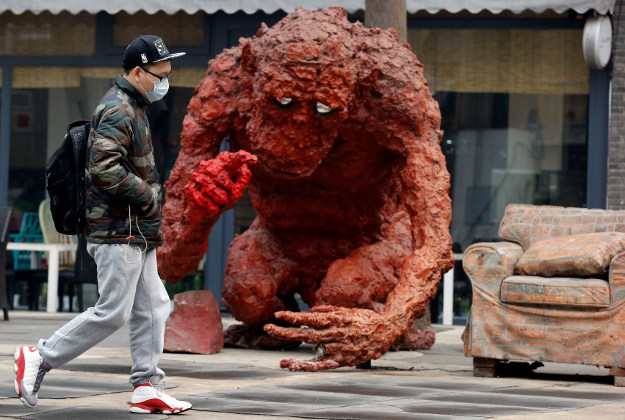 A man wears a mask to protect against the pollution as he walks past a sculpture in Beijing, China, Wednesday, Dec. 9, 2015. Image by AP Photo/Ng Han Guan.