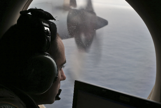 In this March 22, 2014 file photo, flight officer Rayan Gharazeddine on board a Royal Australian Air Force AP-3C Orion, searches for the missing Malaysia Airlines Flight MH370 in southern Indian Ocean, Australia.