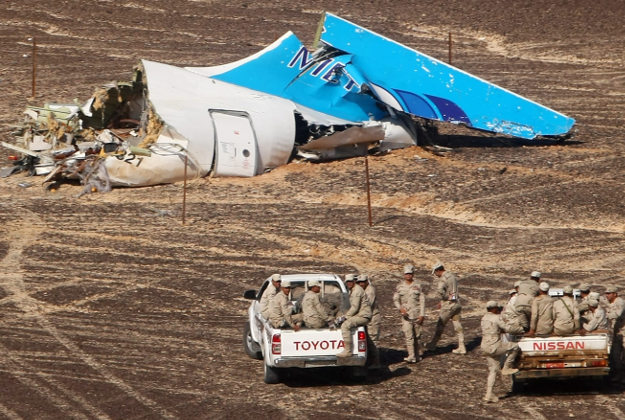 Egyptian Military on cars approach a plane's tail at the wreckage of a passenger jet bound for St. Petersburg in Russia that crashed in Hassana, Egypt, on Sunday, Nov. 1, 2015. 