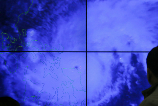 Government meteorologists monitor from a satellite image of Typhoon Melor fat the weather bureau center in suburban Quezon city, northeast of Manila, Philippines as it hits the eastern Philippines. 