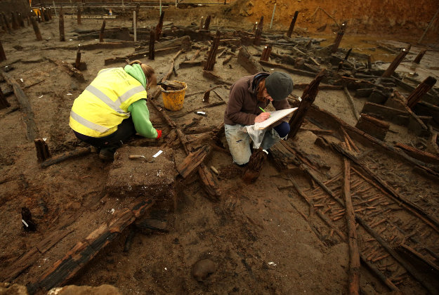 Archaeologists work on the site of a Bronze Age settlement destroyed in a fire 3,000 years ago, at Must Farm quarry in Cambridgeshire.